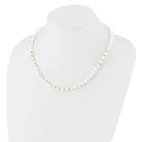 A white pearl beaded necklace with gold-tone spacer beads displayed on a white mannequin bust.