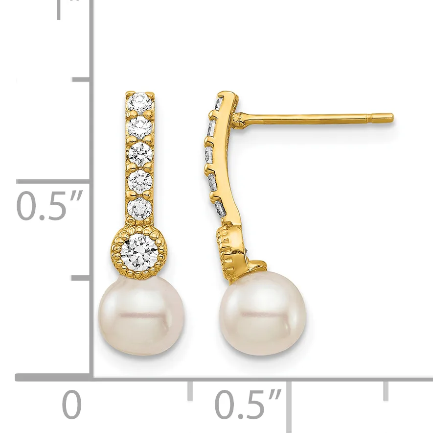 Pair of gold drop earrings with diamond-studded posts and settings, each suspending a round white pearl, shown next to a ruler for scale.