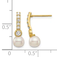 Pair of gold drop earrings with diamond-studded posts and settings, each suspending a round white pearl, shown next to a ruler for scale.