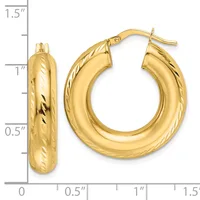 Pair of polished gold hoop earrings with textured sides, shown with a measurement scale indicating approximately one inch in diameter.