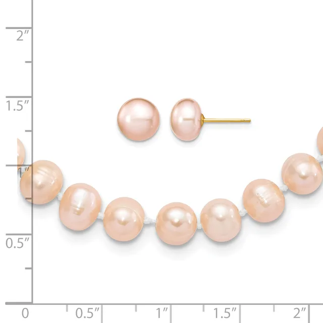 A peach-colored pearl bracelet and matching stud earrings displayed against a ruler showing measurements up to two inches.