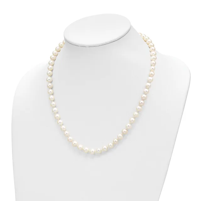 A single strand of cream-colored round pearls displayed on a white mannequin bust necklace form.