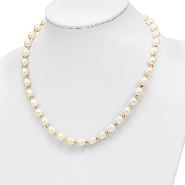 A necklace made of alternating cream-colored pearls and small gold-tone beads displayed on a white mannequin bust.