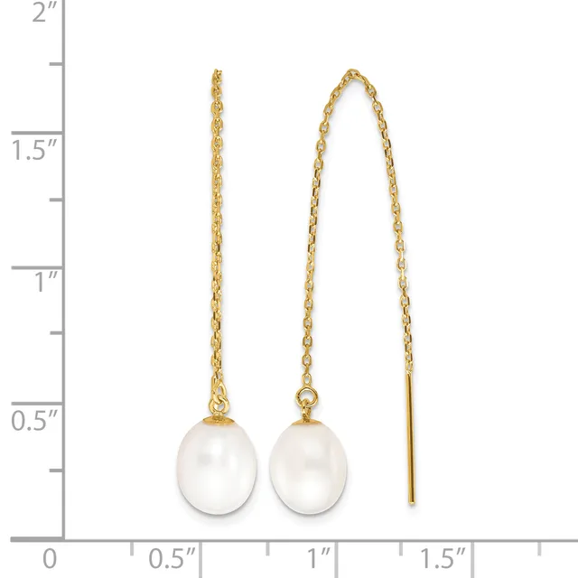 Two pairs of gold earrings with white pearl drops displayed against a ruler showing measurements up to two inches.