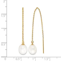 Two pairs of gold earrings with white pearl drops displayed against a ruler showing measurements up to two inches.