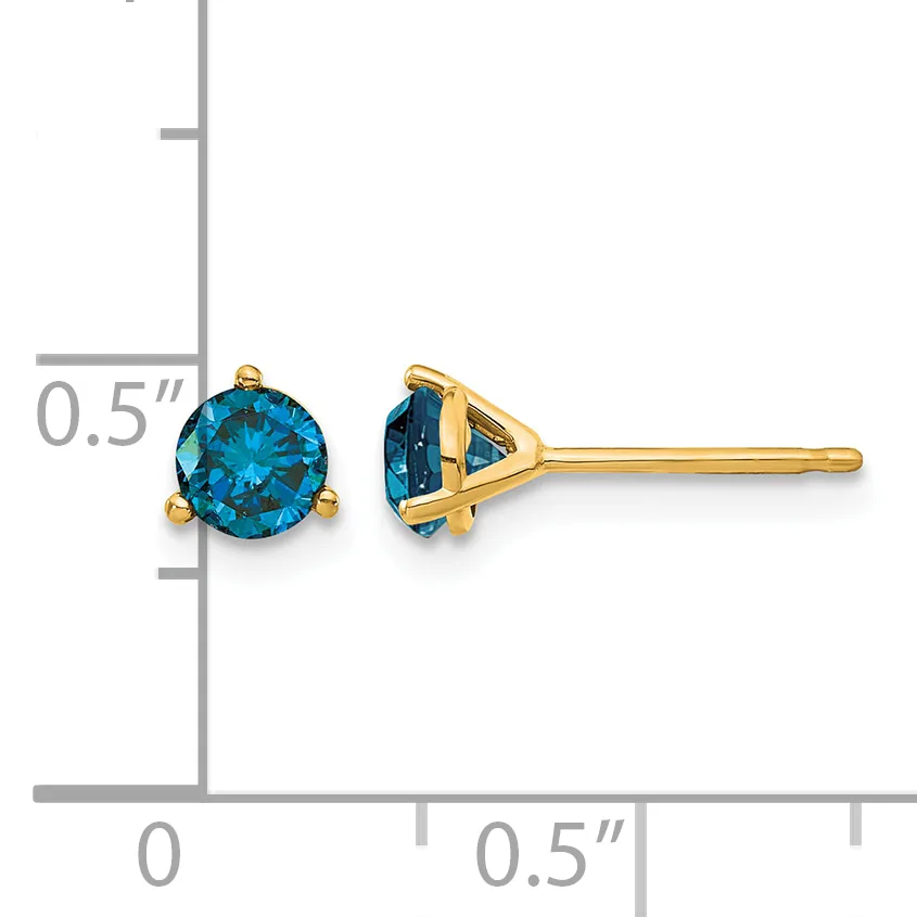 A pair of gold stud earrings with round blue gemstones displayed next to a ruler showing approximately half-inch size.