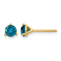 A pair of gold stud earrings with round blue topaz stones set in three-pronged settings, shown from front and side views.