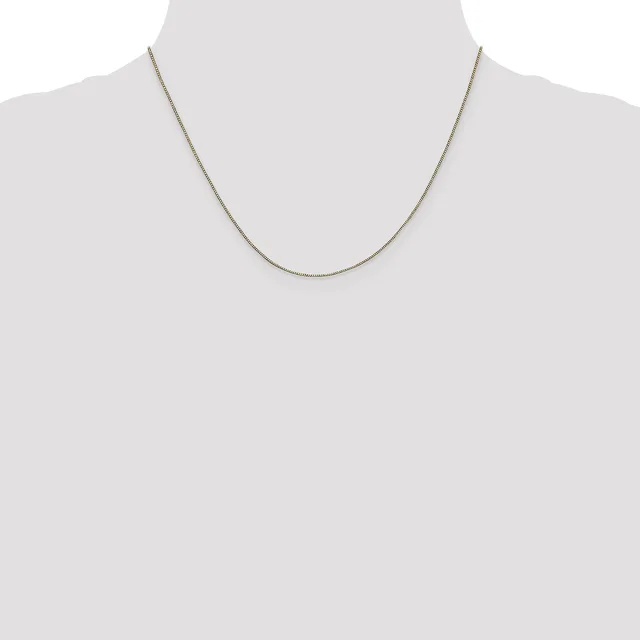 A thin silver-toned chain necklace displayed on a mannequin neck form against a light gray background.
