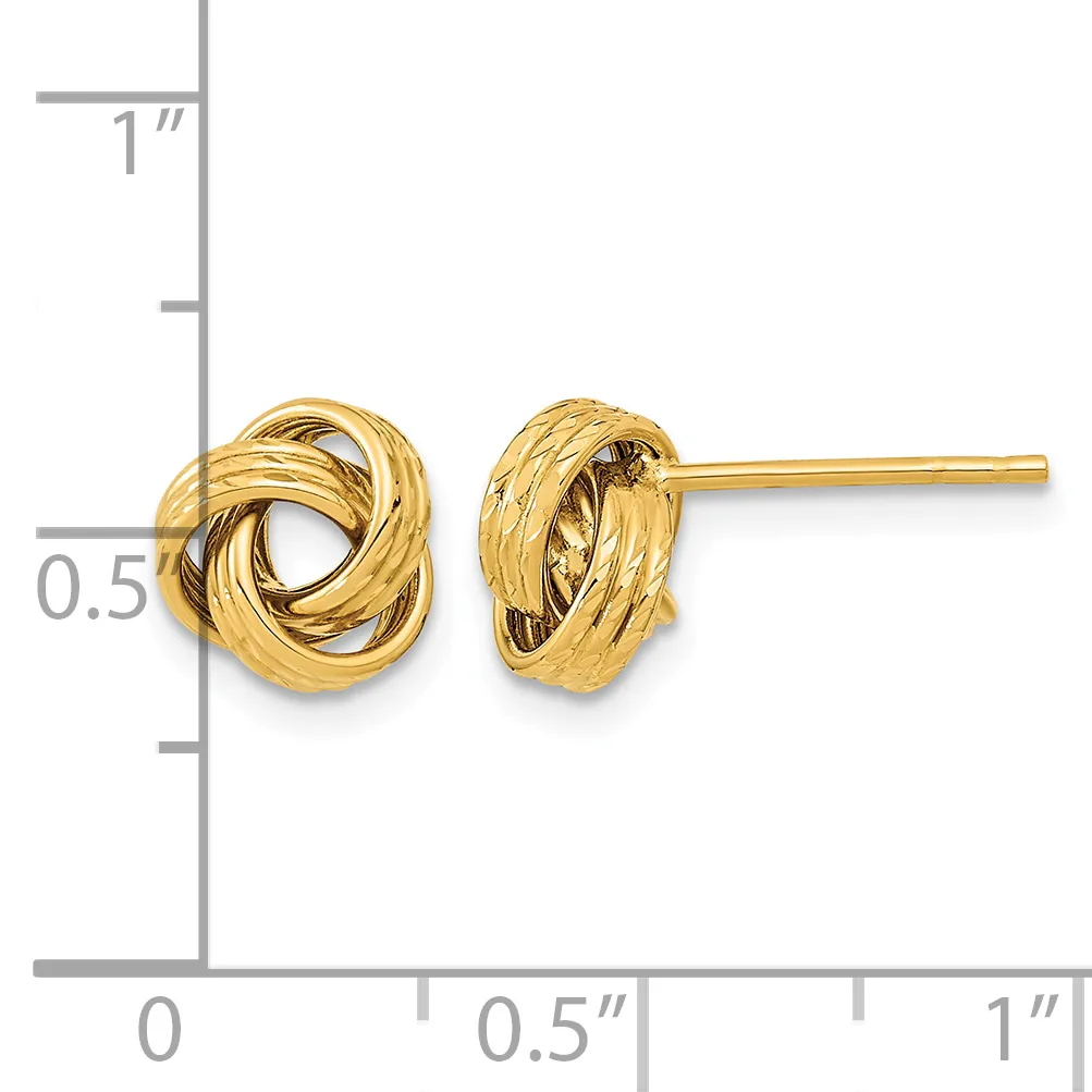 Pair of gold-toned twisted knot stud earrings displayed on a ruler showing approximately half-inch diameter size.