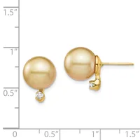 Two champagne-colored pearl stud earrings with small diamond accents, displayed against a measurement scale showing approximately one inch in height.