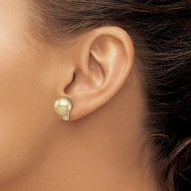 A woman wearing a pearl stud earring with small diamond accents, shown from the side view of her ear and neck.