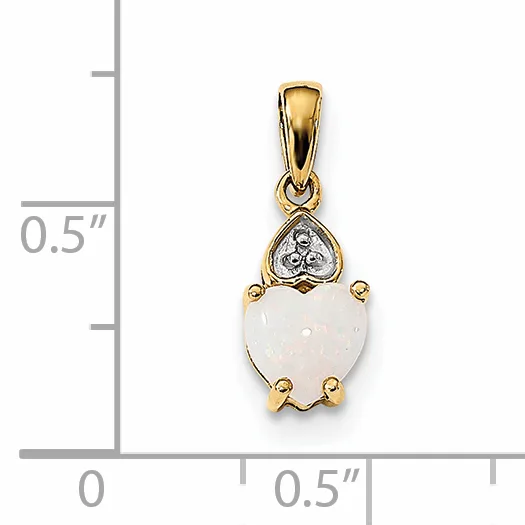 A gold pendant featuring a heart-shaped white stone topped with a diamond accent, displayed next to a ruler showing approximately 0.5 inches in height.