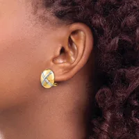 A person wearing a gold and silver crossover earring with a curved post, shown from the side view against their ear and neck.