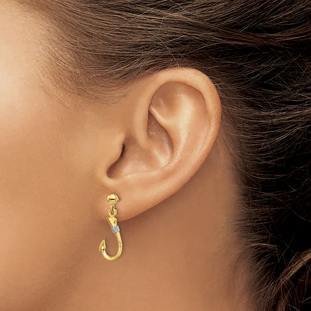 A person wearing a gold hoop earring with a small diamond accent, shown from the side view of their ear and neck.