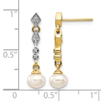 A pair of yellow gold drop earrings with diamond-set geometric tops and pearl bottoms, displayed against a measurement scale showing approximately one inch in length.
