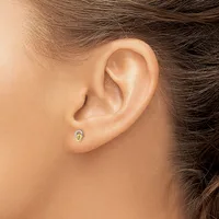 A small oval stud earring with a blue stone and gold-toned metal setting worn in a pierced earlobe.