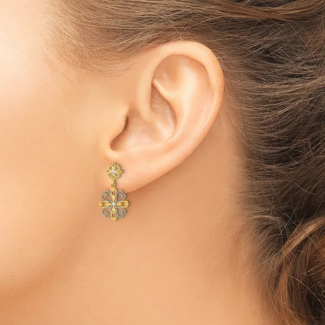 A woman wearing a two-tier flower-shaped drop earring with yellow and white gemstones set in metal, shown from the side view of her ear and neck.