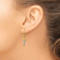 A person wearing a gold-toned drop earring with textured details and a small diamond or crystal accent, shown from the side view of their ear.