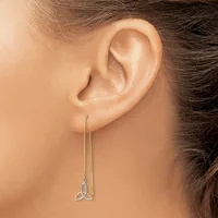 A person wearing a long chain threaded earring with a small trinity knot pendant in silver-toned metal, shown from the side view of their ear.