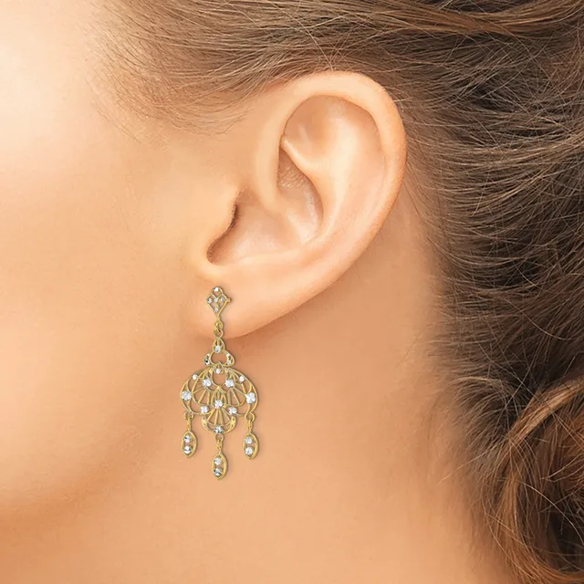 A woman wearing a chandelier-style drop earring with a fan-shaped top and multiple small hanging teardrop crystals, shown from the side view of her ear.