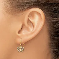 A gold-toned butterfly-shaped earring with clear gemstones hangs from a curved hook on a person's earlobe.