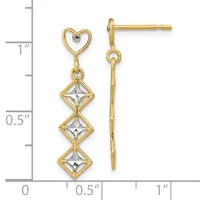 Gold-tone heart stud earrings with three dangling diamond-shaped white stone accents, shown against a measurement scale.