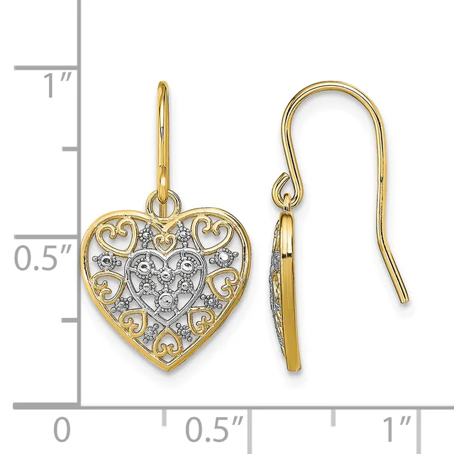 Pair of gold heart-shaped dangle earrings with decorative filigree borders and diamond accents, shown on a measurement scale.