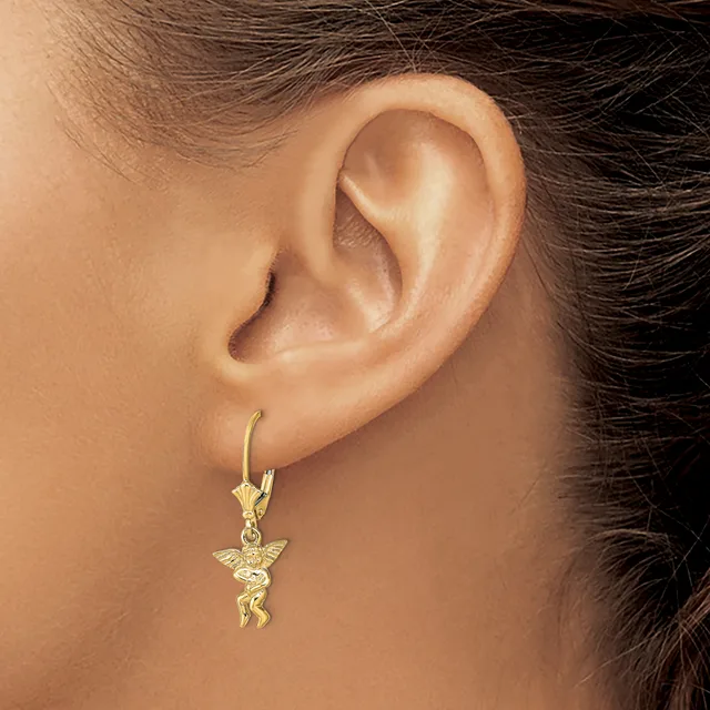 A person wearing a gold lever-back earring with a small winged cherub pendant hanging from it.