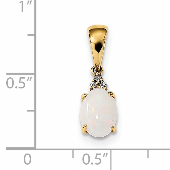 Gold pendant with oval white opal stone and small diamonds on bail, shown next to ruler measuring approximately one inch tall.