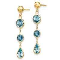 Pair of gold drop earrings with ball studs and three blue topaz gemstones in round and teardrop cuts suspended by chain links.