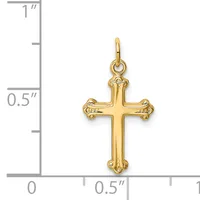 A gold-colored cross pendant with ornate flared ends, shown next to a ruler measuring approximately 0.75 inches tall and 0.5 inches wide.