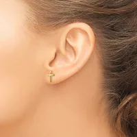 A small gold cross stud earring is worn in the earlobe of a person with brown hair.