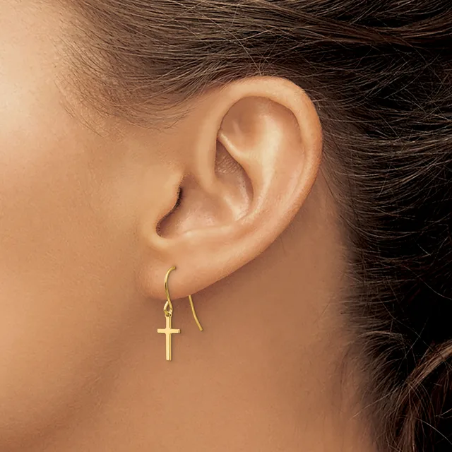 A person wearing gold cross earrings on threader-style hooks, shown from the side profile of their ear and neck.