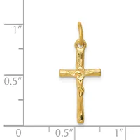 A gold crucifix pendant with a textured corpus, shown against a measurement scale indicating approximately one inch in height.
