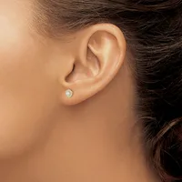 A person wearing a small round diamond stud earring in their pierced earlobe, shown in profile view against their neck and shoulder.