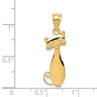 Gold cat pendant with diamond eyes and curved tail, shown next to a ruler indicating approximately one inch in height.