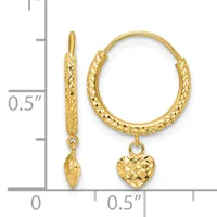 Two gold textured hoop earrings displayed against a measurement scale, one with a dangling heart charm and one with a dangling marquise charm.