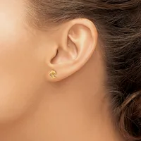 A woman wearing a small gold crescent moon stud earring in her earlobe, shown in profile view.
