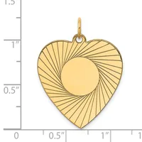 Gold heart-shaped pendant with radiating line pattern and circular cutout in center, displayed against a measurement scale.