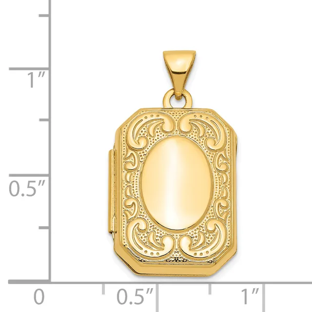 Gold-toned rectangular locket pendant with ornate scrollwork border and polished oval center, shown against a measurement scale.