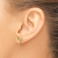 A gold-toned flamingo-shaped stud earring worn on a person's earlobe, shown from the side view.
