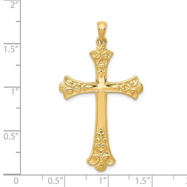 Gold ornate cross pendant with floral filigree details on the arms and shaft, displayed against a ruler showing approximately two inches in height.