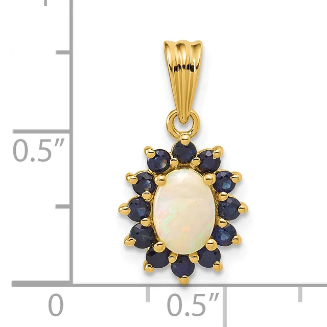Gold pendant with an oval white opal center surrounded by twelve round dark blue sapphires, displayed next to a measurement ruler showing approximately half an inch in height.
