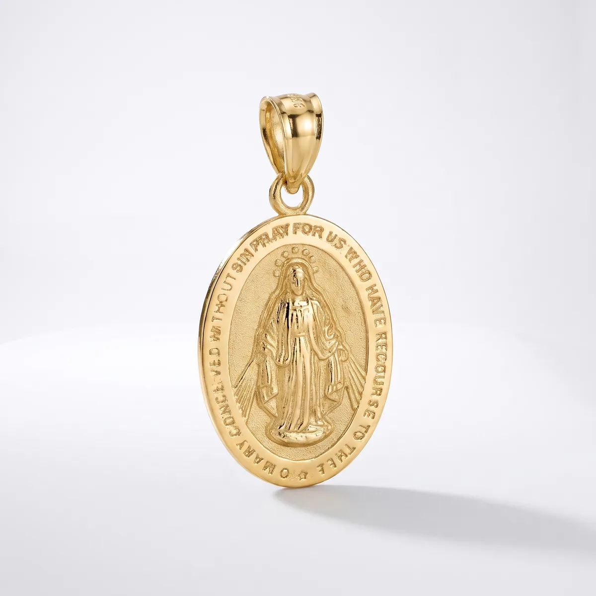 Gold oval religious medal pendant with relief image of a robed figure and text around the border, suspended from a gold bail on white background.