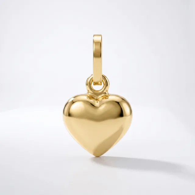 A polished gold heart-shaped pendant with a rectangular bail loop attached to the top, displayed against a white background.