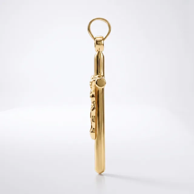 A gold-colored metal keychain pendant with a cylindrical body and decorative charm details attached to a ring loop at the top.