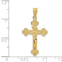 A gold crucifix pendant with ornate trefoil ends on the arms and shaft, shown next to a ruler indicating approximately 1.25 inches in height.