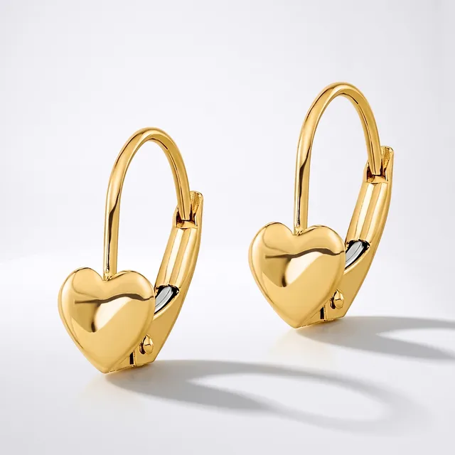 A pair of glossy gold heart-shaped leverback earrings with a hinged hook and a small stamped hallmark on the back of each heart, displayed against a white background.