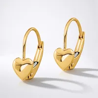 A pair of glossy gold heart-shaped leverback earrings with a hinged hook and a small stamped hallmark on the back of each heart, displayed against a white background.