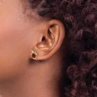 A person wearing a small gold heart-shaped stud earring with a red gemstone in the center, shown from the side profile.